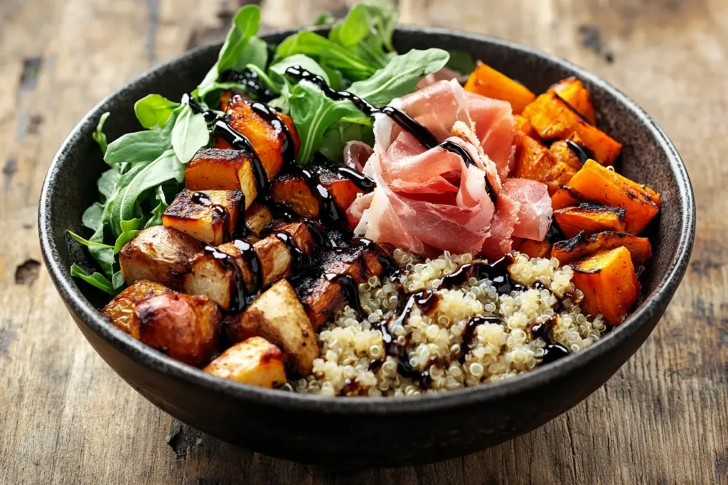 A sophisticated Buddha Bowl with roasted vegetables, quinoa, and prosciutto.